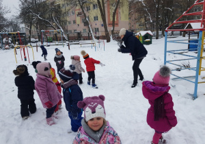dzieci w ogrodzie podczas zabawy na śniegu