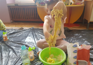 dziecko wyrabiające masę plastyczną w misce