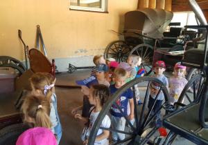 grupa dzieci ogląda powóz konny przeznaczony do wyścigów