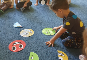 Dziecko układa kropki na dywanie