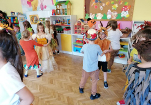 dzieci w strojach podczas zabawy na balu w sali przedszkolnej