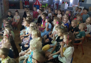 grupa dzieci podczas oglądania filmu edukacyjnego w zaciemnionej sali