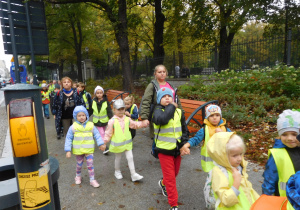 grupa dzieci ubrana w kamizelki podczas spaceru w centrum miasta