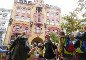 grupa dzieci ubrana w kamizelki podczas spaceru w centrum miasta