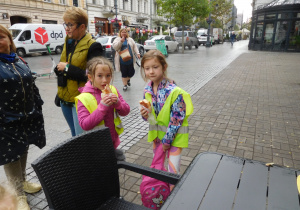 dzieci wzmacniają się przekąską z plecaka w centrum miasta