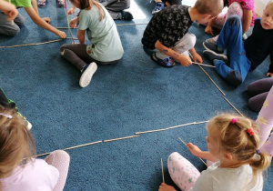 dzieci na dywanie układajace z patyczków