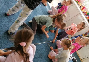 dzieci na dywanie układajace z patyczków