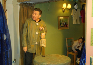 aktor trzyma marionetkę wykorzystaną w spektaklu