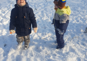 Dwoje dzieci stojących na śniegu