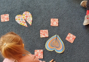 dziewczynka układa puzzle na dywanie