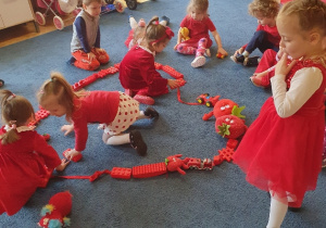 dzieci w czerwonych strojach tańczą