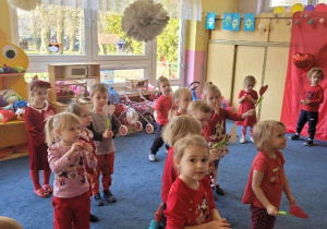 grupa dzieci w czerwonych strojach tańczy