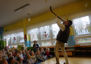 Góral demonstruje dzieciom grę na instrumencie muzycznym
