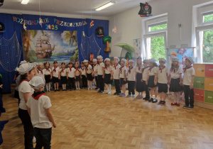 Dzieci z grup IV i V stoją w półkolu.