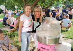 Nauczycielki pozują do zdjęcia przy maszynie do robienia waty cukrowej.