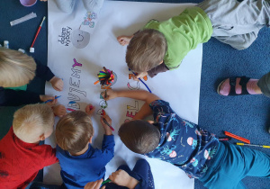 dzieci widziane od góry malują plakat