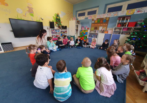 grupa dzieci siedzi na dywanie w kole