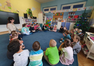 grupa dzieci siedzi na dywanie w kole