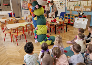 kobieta dzwiga wielką stonogę pluszową