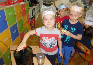 dzieci wyciskają sokz użyciem sokowirówki