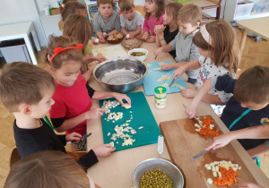 dzieci przygotowujace sałatkę