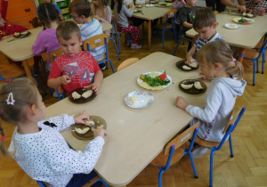 dzieci przy stoliku wykonują kanapki