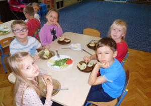 dzieci przy stoliku wykonują kanapki
