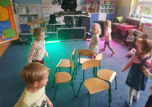 dzieci w sali podczas zabawy z DJ w konkursie z krzesełkami