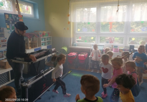 dzieci w sali podczas zabawy z DJ ze sztucznym dymem