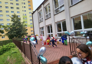grupa dzieci podczas zabawy z balonami na tarasie przedszkola