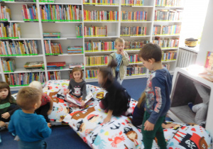 dzieci w sali bibliotecznej na miękkich poduchach
