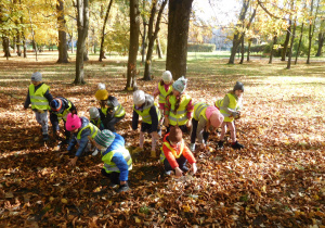 dzieci podczas spaceru z jesiennymi liściami