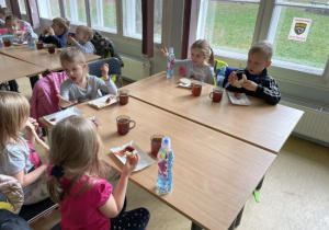 dzieci przy stolikach przy posiłku