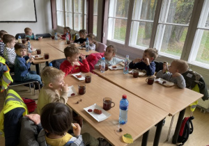 dzieci przy stolikach przy posiłku