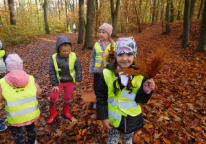 dzieci w kamizelkach odblaskowych podczas spaceru w lesie