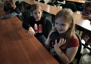 dzieci siedząca w łakach szkolnych w muzeum