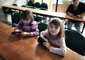 dzieci siedząca w łakach szkolnych w muzeum