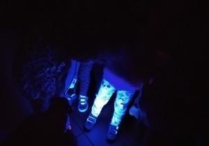 podświetlone nogi dzieci w specjalnej sali muzealnej wykorzystującej światło fluorescencyjne