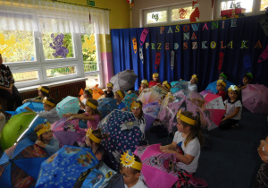 grupa dzieci w sali z rozłożonymi parasolkami