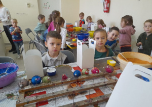 dzieci przy stolikach podczas dekorowania bombek