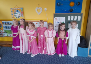 grupa dziewczynek ubrana w długie różowe i biale sukienki