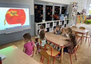 dzici oglądają film edukacyjny w klasie na tablicy interaktywnej