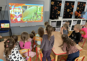 dzici oglądają film edukacyjny w klasie na tablicy interaktywnej